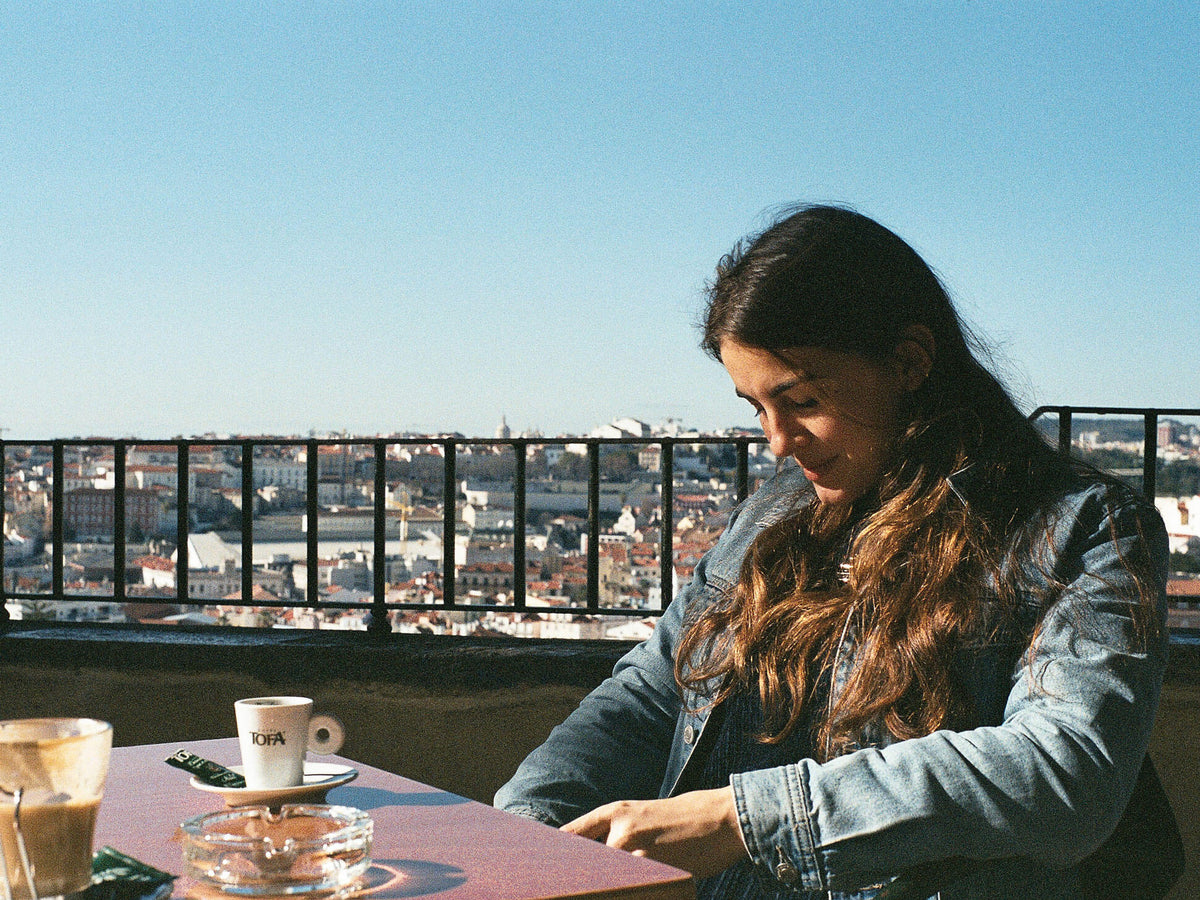 Frau trinkt Kaffee an Aussichtspunkt von Lissabon