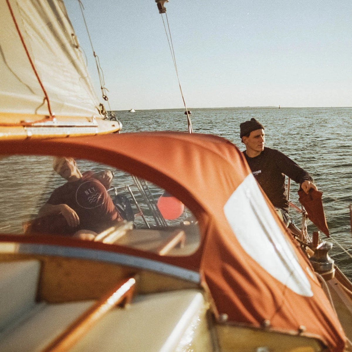 Vater und Sohn segeln bei Sonnenuntergang vor Norderney