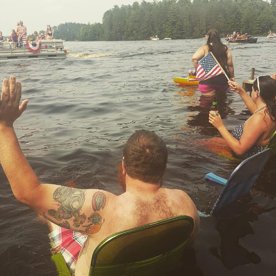  group sitting in the lake waving at boats going by 