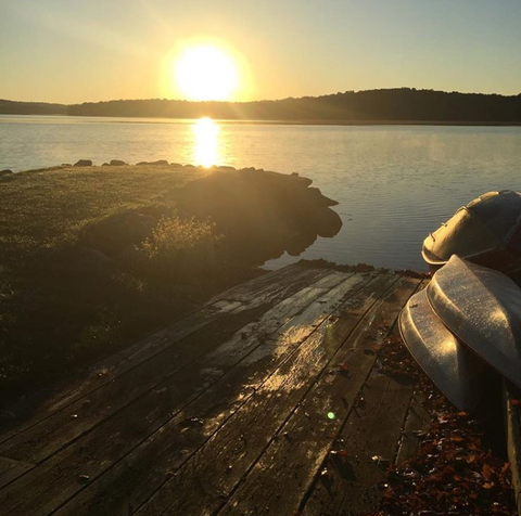 sunset over the lake with canoes on the shore