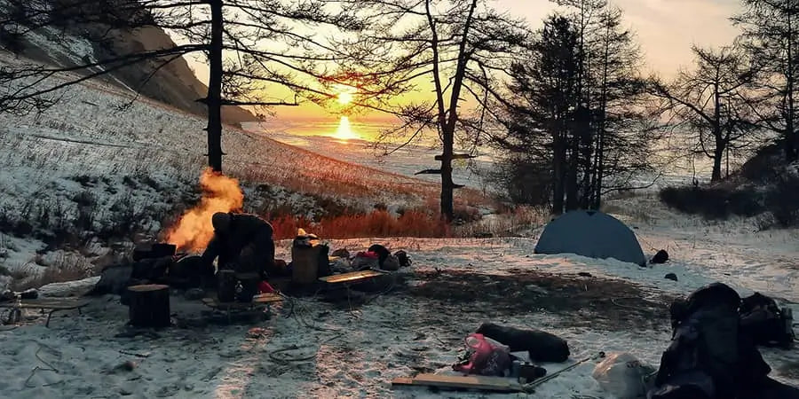 Winter campsite with snow and fire in the early morning