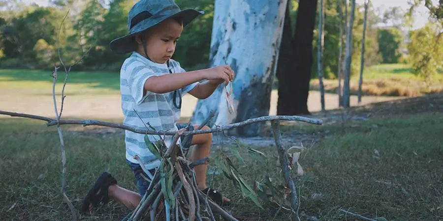 child helping establish a campfire