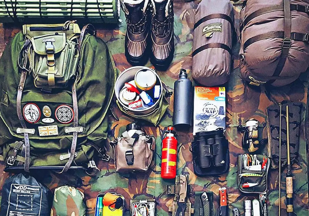 Camping gear laid out upon a camouflage blanket