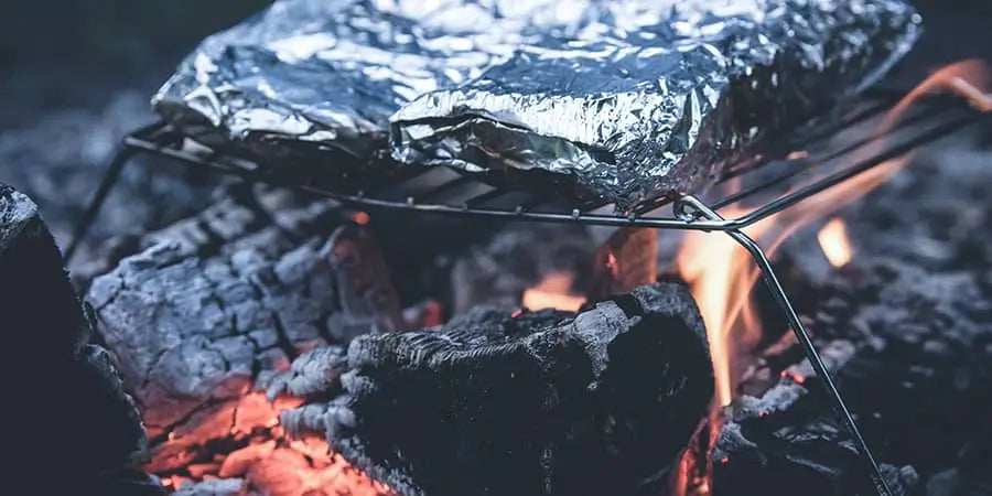 Cooking food wrapped in foil under a wood fire