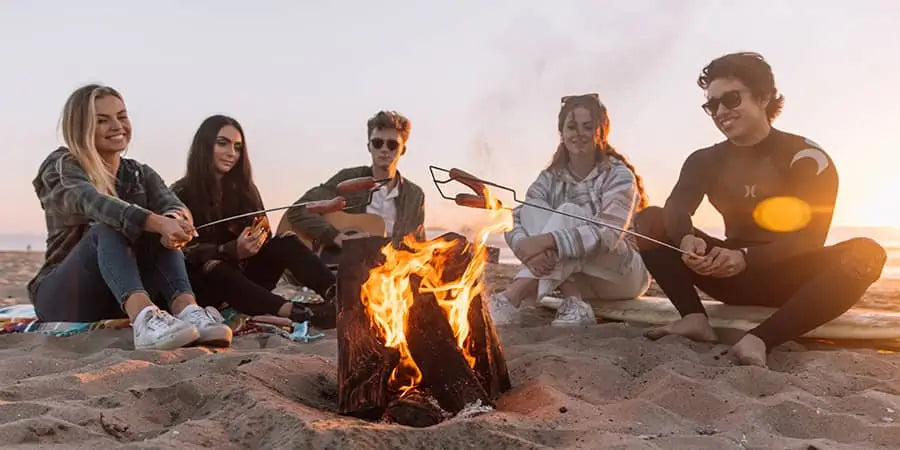 group of young friend roasting marshmallows in their fire pit