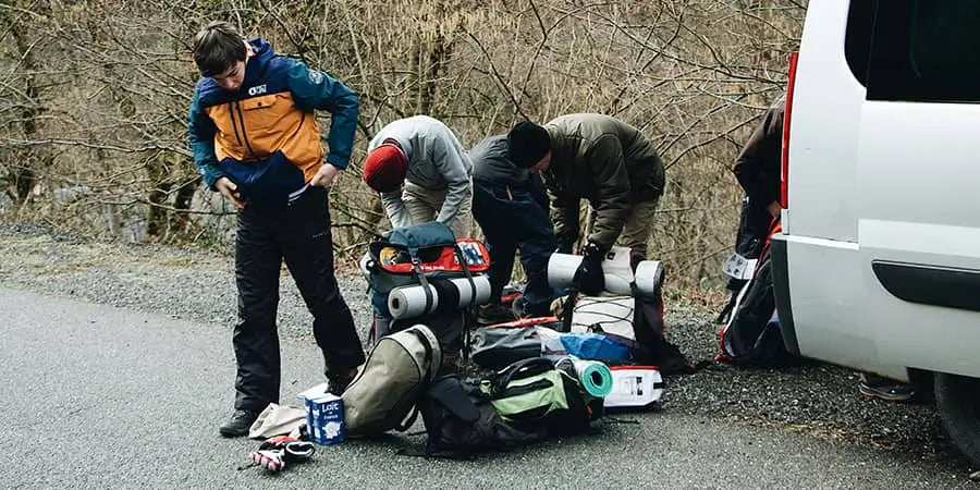 group double checking snow gear on the side of the road.