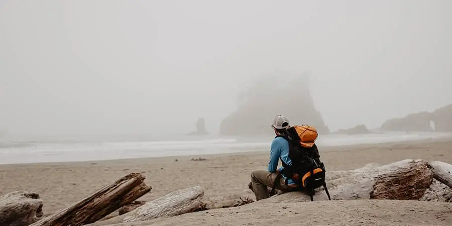 Man sitting on the beach in the early morning