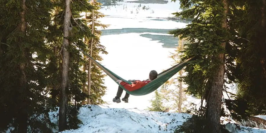 Man swinging in ayamaya camping hammock in the snow