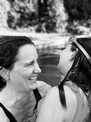 Black and white photo of a white female laughing and looking at her duaghter.