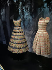 Two Dior dresses on black mannequins, the one on the left with blue stripes, the one on the right with floral stripes