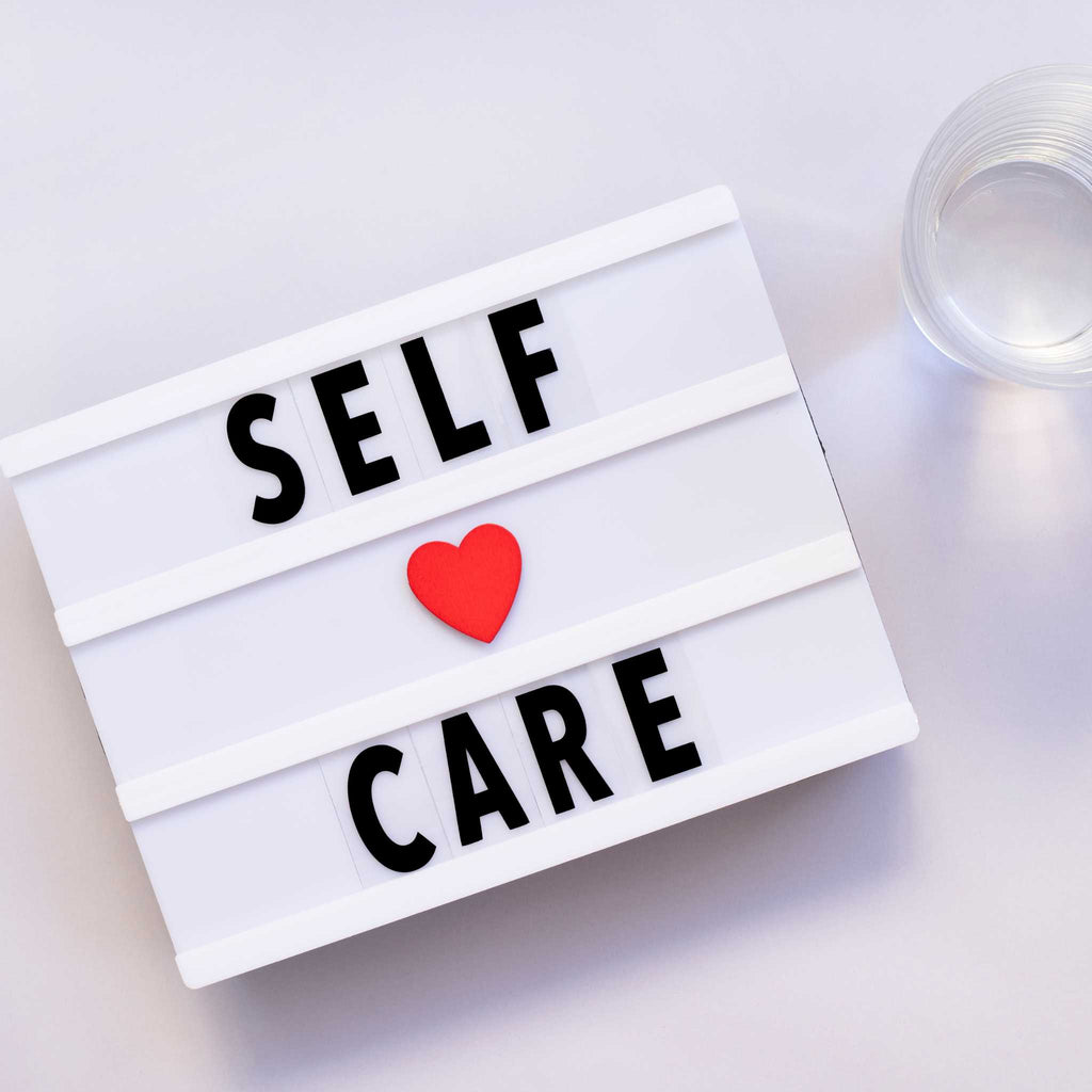 Self-care sign with heart and glass of water