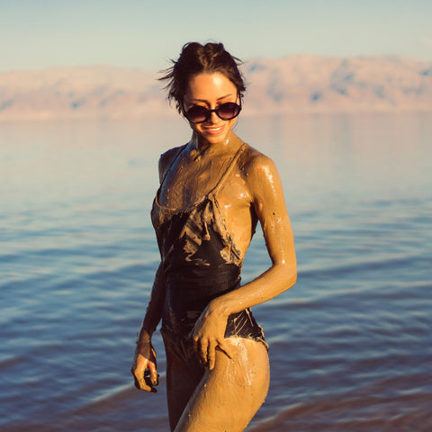 A woman at the Dead Sea covered in Dead Sea mud