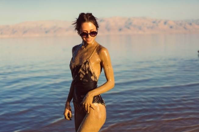 Woman covered in Dead Sea mud at the Dead Sea