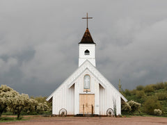 Abandoned rustic white church in arizona desert on a stormy day