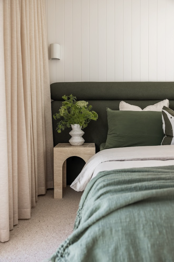 mediterranean coastal master bedroom with green boucle bed head