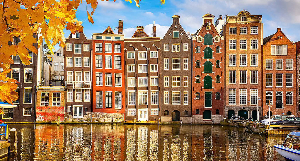 Colourful brown and orange  buildings along the river in Amsterdam