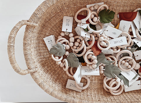 Baby rattles and teethers in wicker basket by Bezisa