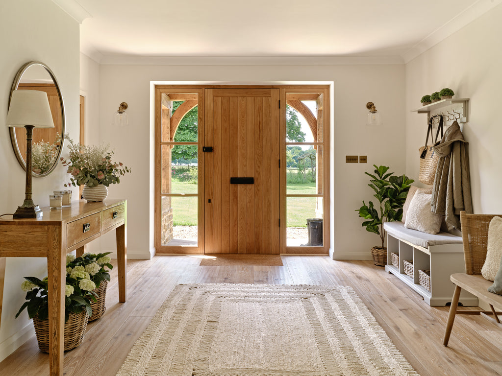 Entryway with cream walls and natural wood door plus wooden cabinet