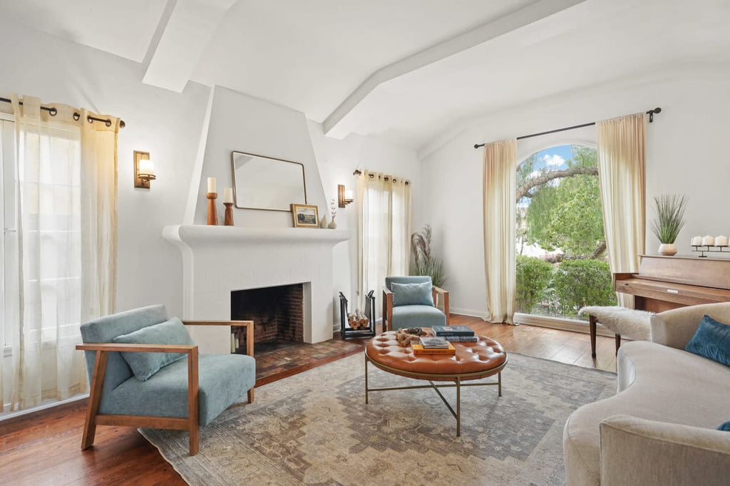 Light living room with white sofa blue armchair and fireplace