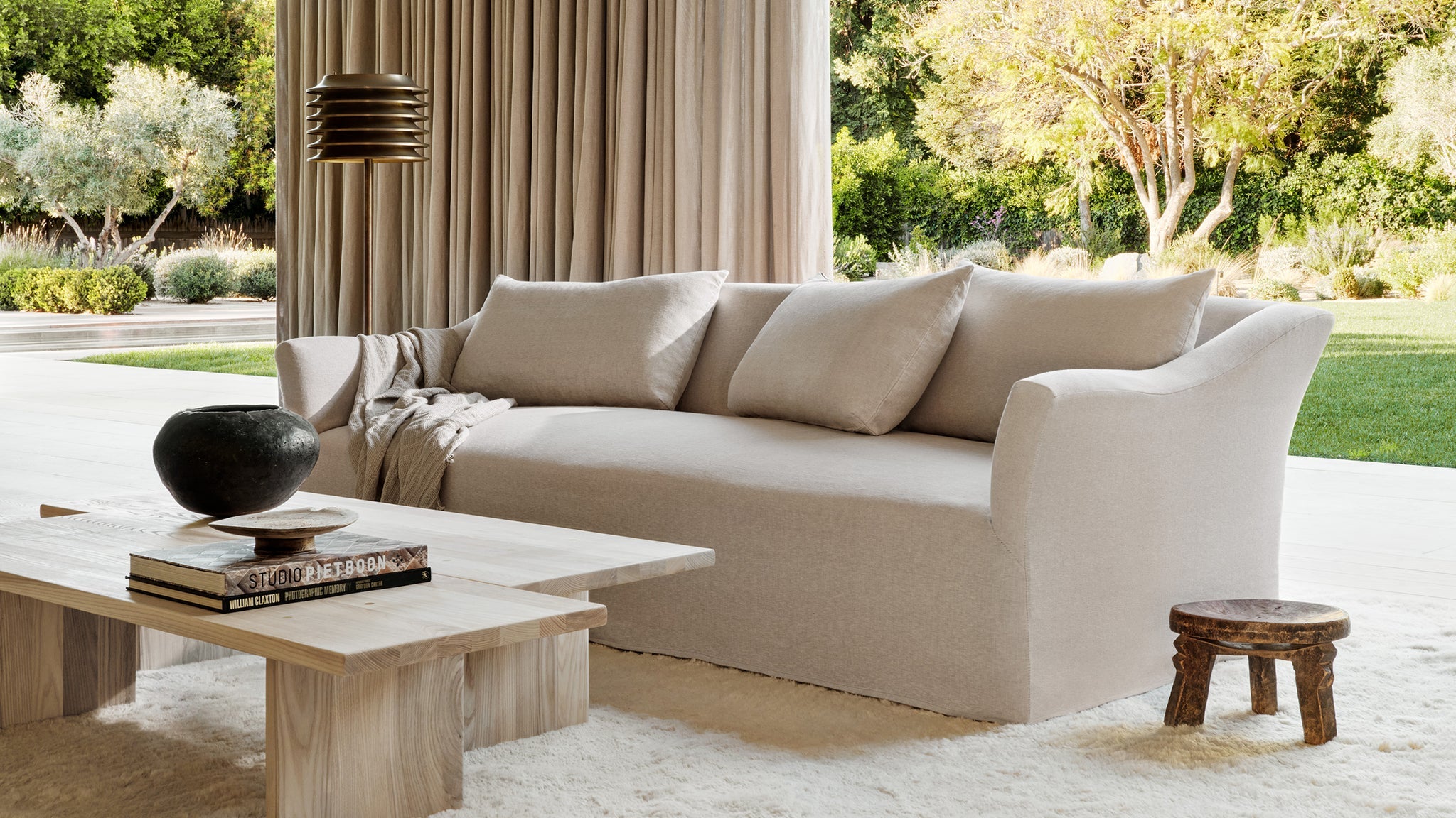 Loose cover linen sofa with sweeping arms beside the window