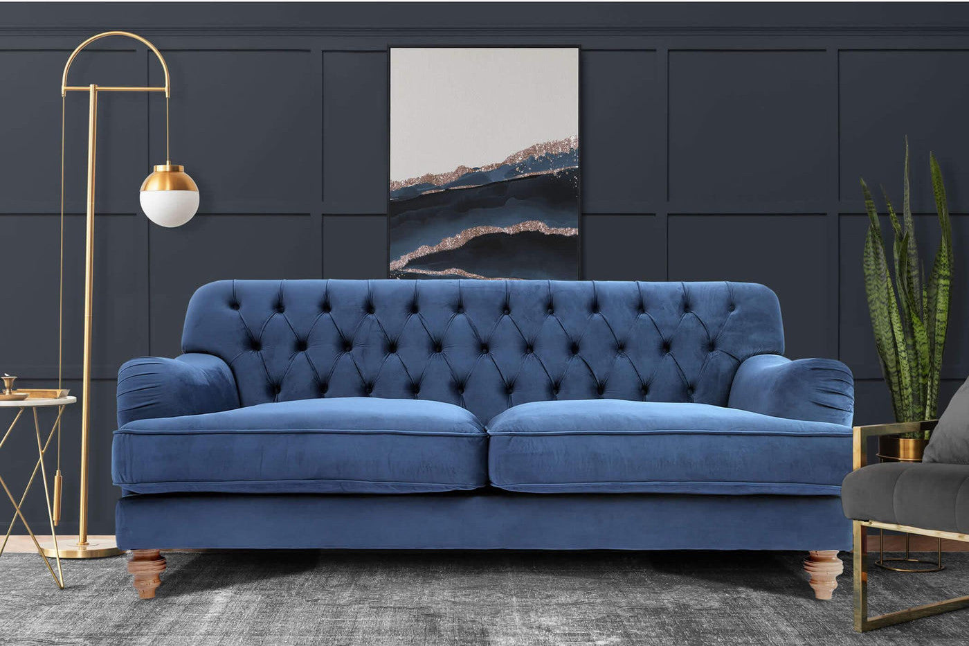 Royal blue deep buttoned sofa in a dark living room