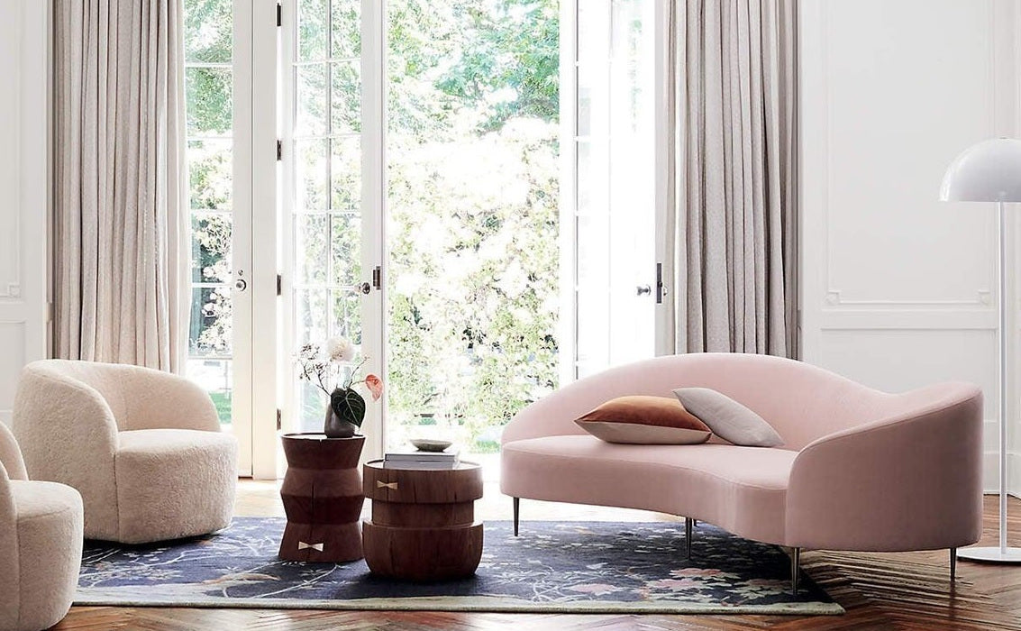 Curved sofa and armchairs placed next to a large window