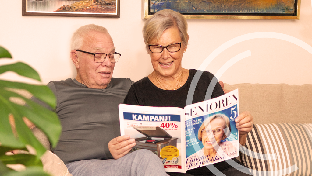 Ett äldre par läser tidningen senioren iförda LifeHip höftskyddsbyxor