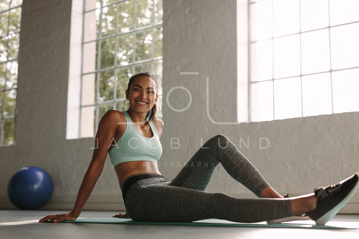 Smiling woman resting after workout – Jacob Lund Photography Store ...