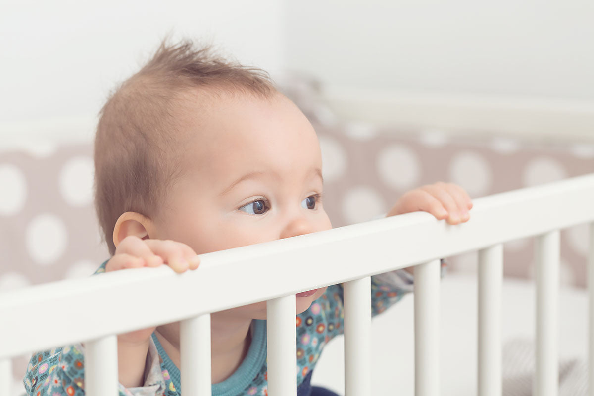 Baby schaut aus Gitterbett