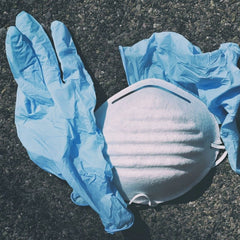 Coronavirus: Plastikhandschuhe und -maske an einem Strand