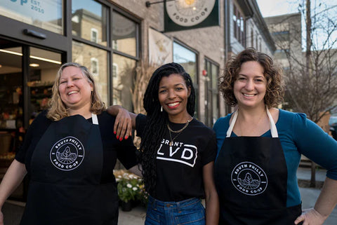 group of people standing outside wearing aprons