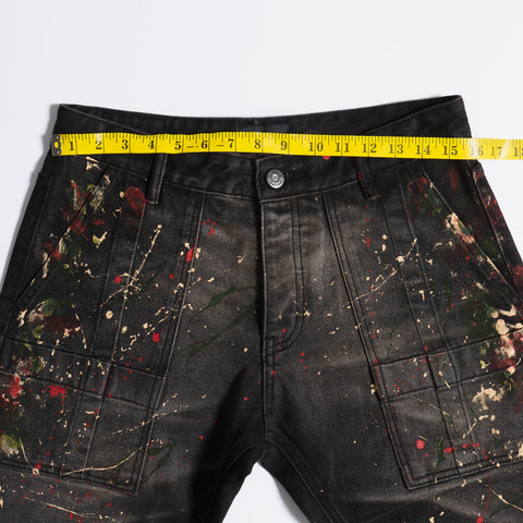 Measuring black paint splatter jeans waist size in waistband