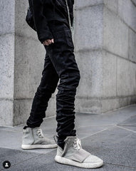 Waist down photo with blacked stacked pants and sneakers