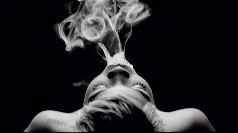 A woman exhaling vape smoke