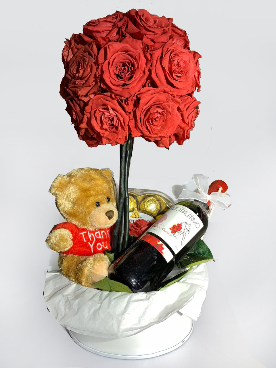 arreglo floral en balde con rosas preservadas, peluche, vino y chocolates