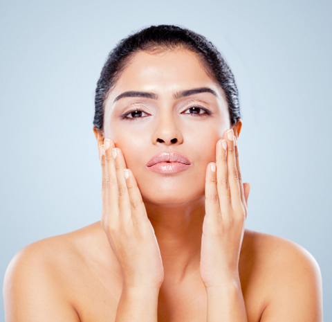 Indian woman cleansing massaging her face