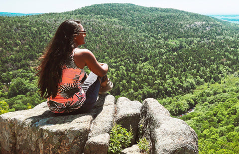 woman hiking sitting on rock enjoying nature