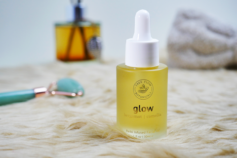 Glow Facial Oil product with green aventurine roller behind it