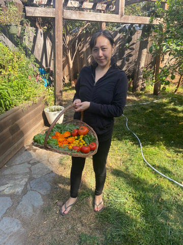 Patty of Free Flow Botanicals proudest moment of 2020 first vegetable garden holding basket of harvest