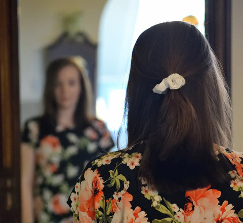 woman looking at herself in mirror work self acceptance love