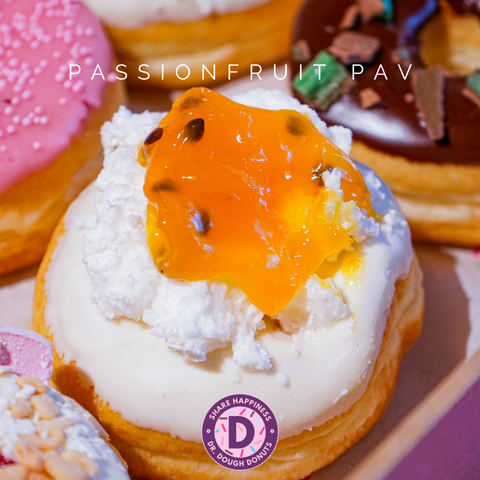 Our Passionfruit Pavlova Donut that is part of the Backyard Favourite Flavours box and is topped with white chocolate glaze with meringue and passionfruit compote.