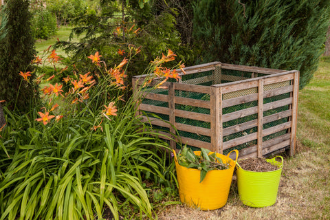 Composting process illustrated with a bin and waste buckets in a lush garden.