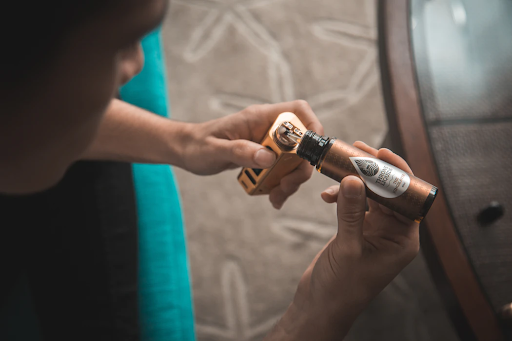 A person filling a vape kit with a shortfill bottle