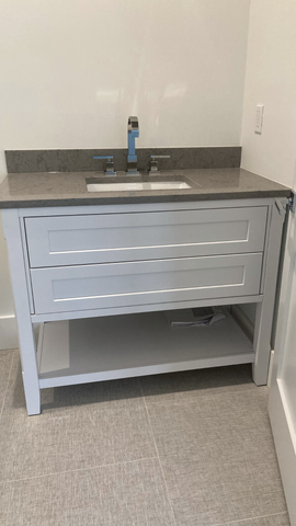 White Furniture Vanity with two drawers and open shelf. Gray quartz countertop. DirectCabinets.com