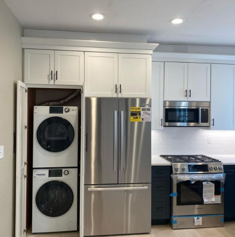 Walk through pantry used for stackable washer and dryer in the kitchen