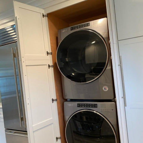 Stackable washer and dryer hidden within the kitchen