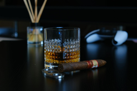 a cigar on a black table next to a shot of whiskey – Compartés