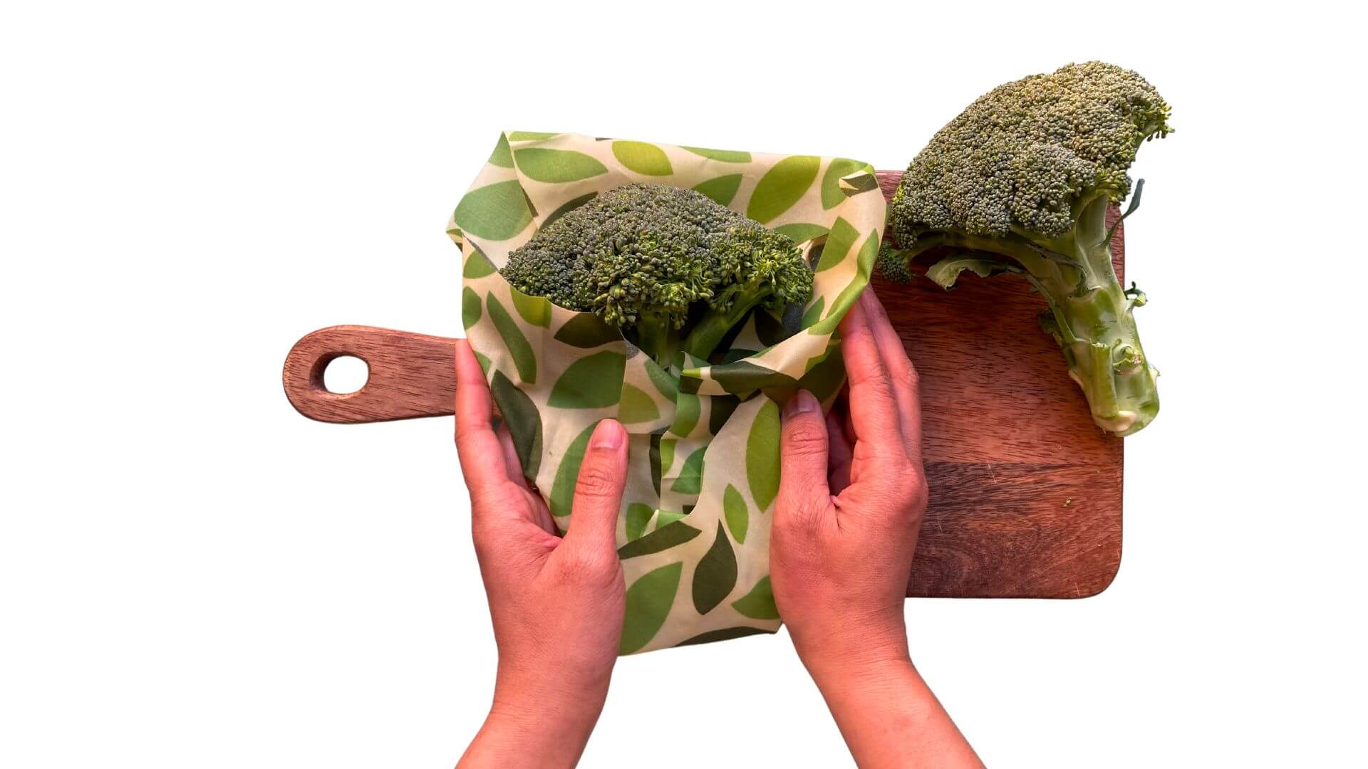 Collombatti Naturals Beeswax Wraps FAQ picture of hands wrapping broccoli in a beeswax wrap