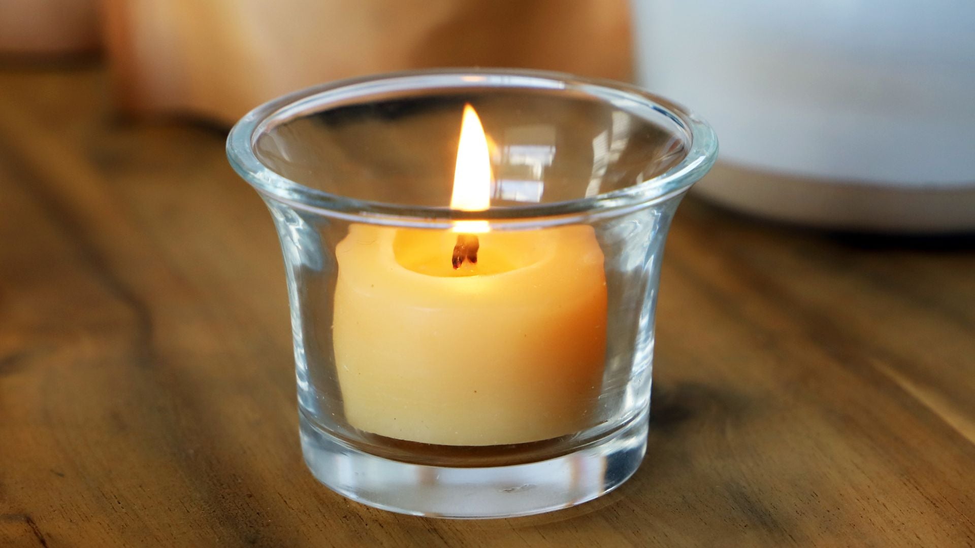 Collombatti Naturals Why beeswax candles are the eco-friendly choice picture of a single beeswax tea light burning in a glass candle holder