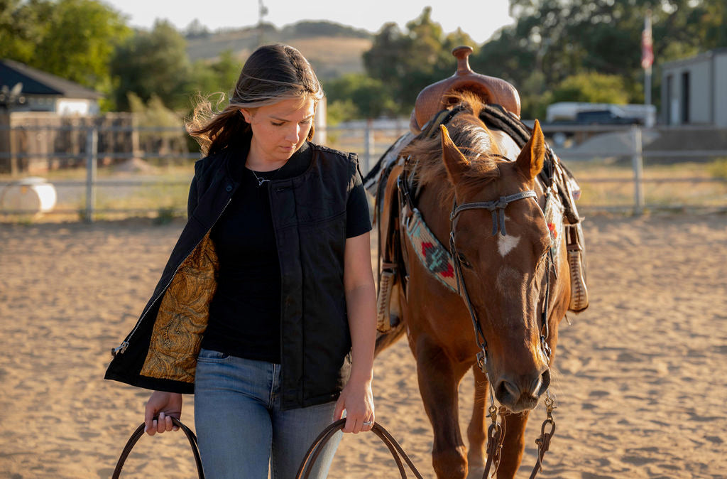 girl wearing a vest with a horse